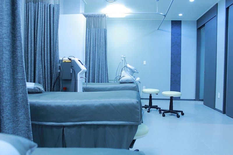 Post-procedure recovery bay with partitioned beds, privacy curtains and monitoring equipment